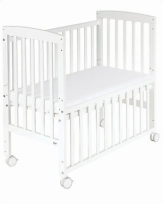 baby crib next to bed